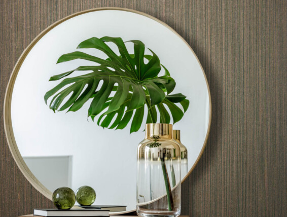 Minimalistic composition at modern retro interior with design commode, tropical leaves in vase, round mirror, copy space, book, grunge wall and elegant accessories in stylish home decor.
